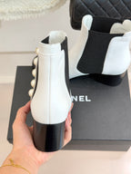 Back view of white ankle boot with pearl side detail and dark block heel