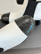 Close-up of white ankle boot toe with black glossy decorative panel