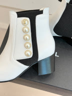 White ankle boot with black elastic gore, gold emblem and pearl row detail on shaft