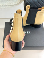 Chanel beige Chelsea boots with black elastic gore and pearl trim along the outer side