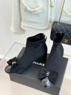 Chanel ladies suede ankle boots with side bows, block heel and gold-tone accents.