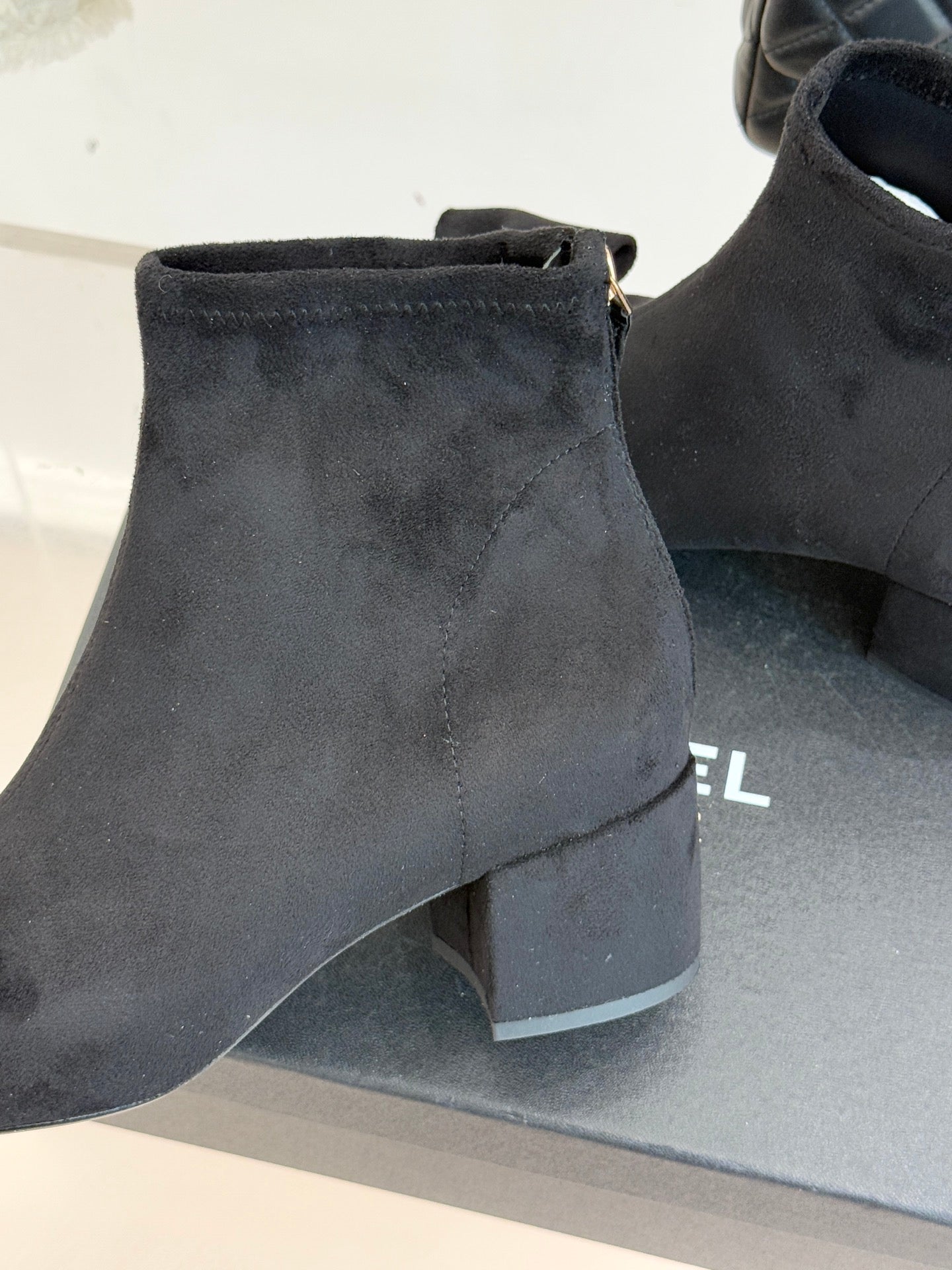 Chanel ladies ankle boots close-up of suede upper and block heel, dark blue.