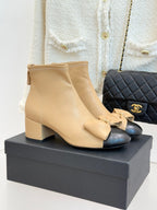 Beige leather ankle boots with block heel, bow detail, and side zipper