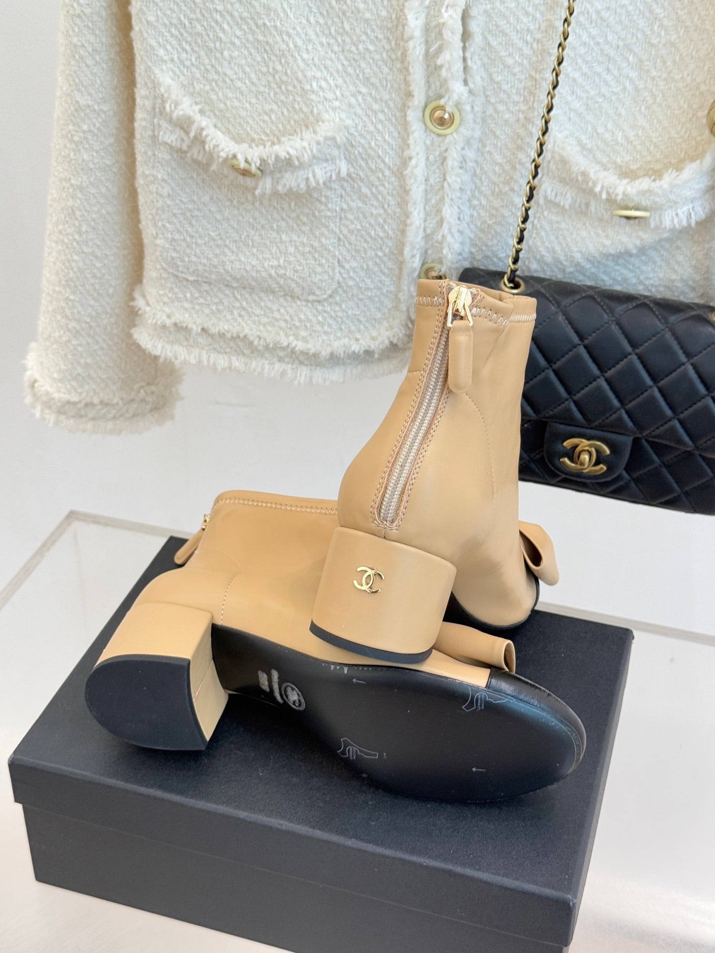 Beige ankle boots with bow, side zipper, and logo emblem on cuff