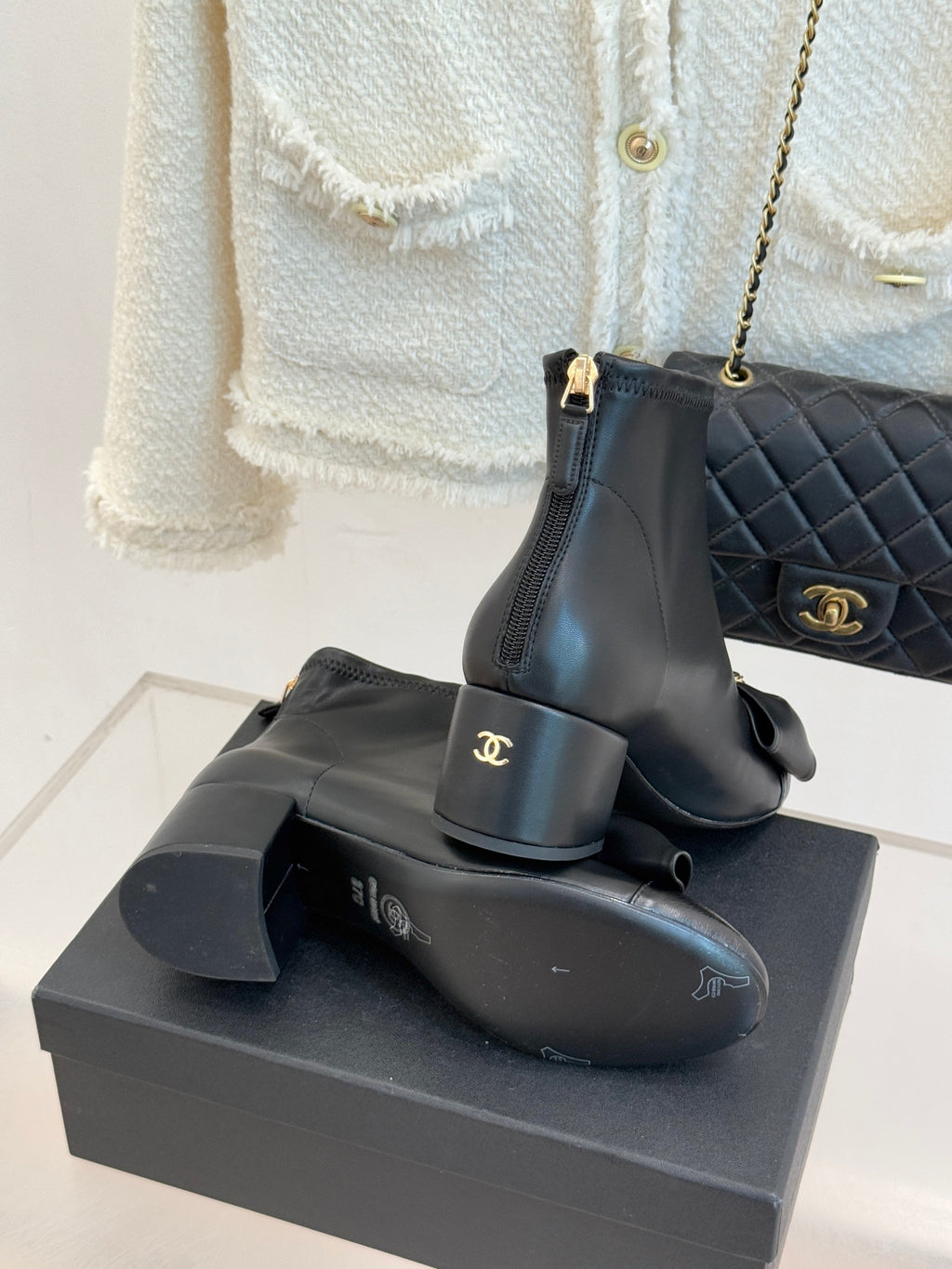Chanel dark navy leather ankle boots with block heel, bow detail, and stacked stance