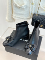 Pair of Chanel dark navy leather ankle boots with bow accents and gold-tone hardware