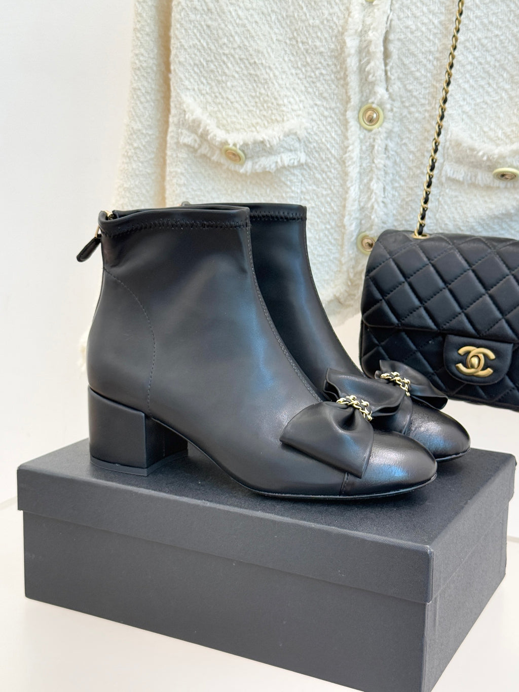 Chanel dark navy leather ankle boots with block heel, bow detail, and gold hardware