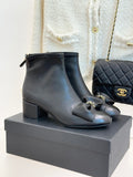 Chanel dark navy leather ankle boots with block heel, bow detail, and gold hardware