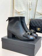 Chanel dark navy leather ankle boots with block heel, bow detail, and gold hardware