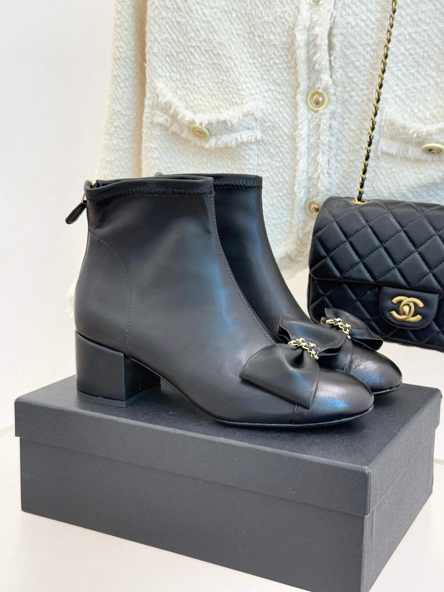 Chanel dark navy leather ankle boots with block heel, bow detail, and gold hardware