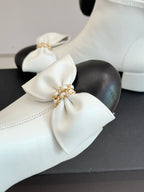 White ankle boot toe with oversized bow and gold-tone chain detail