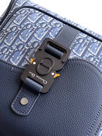 Men's Dior backpack clasp detail on blue leather flap with engraved hardware