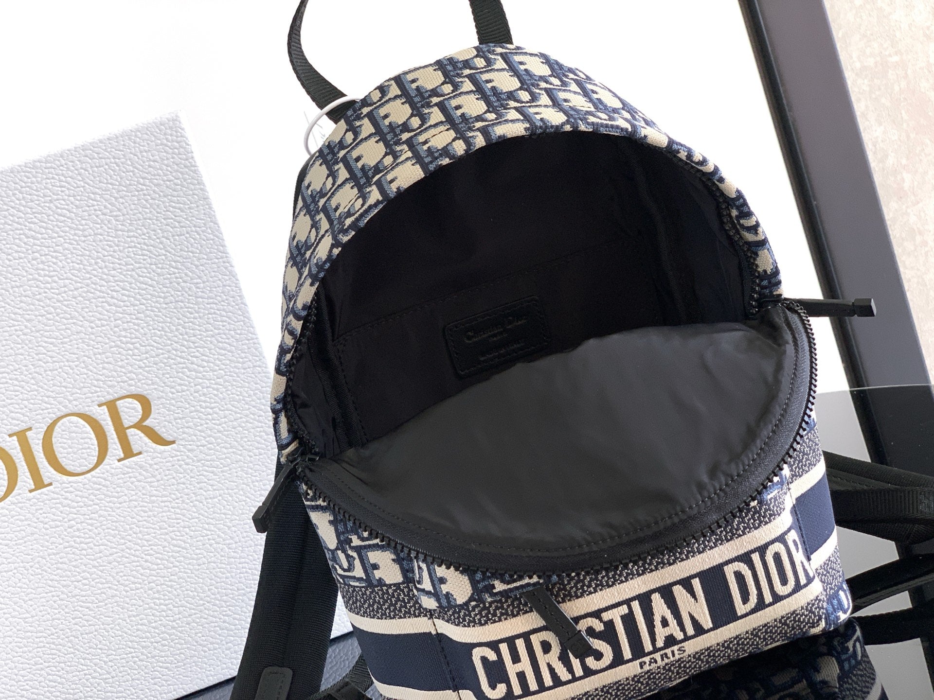Dior backpack interior open view with black lining and top zip opening