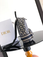 Men’s Dior backpack angled view in blue/cream monogram fabric with black trim
