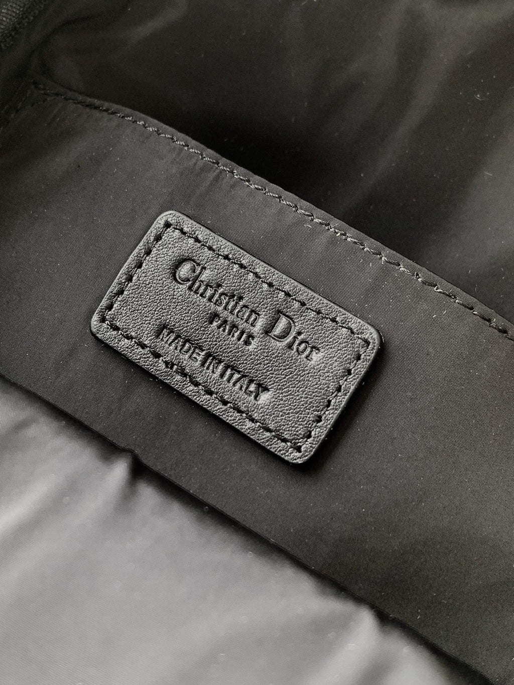 Dior bag internal label reading Christian Dior, Made in Italy on black fabric