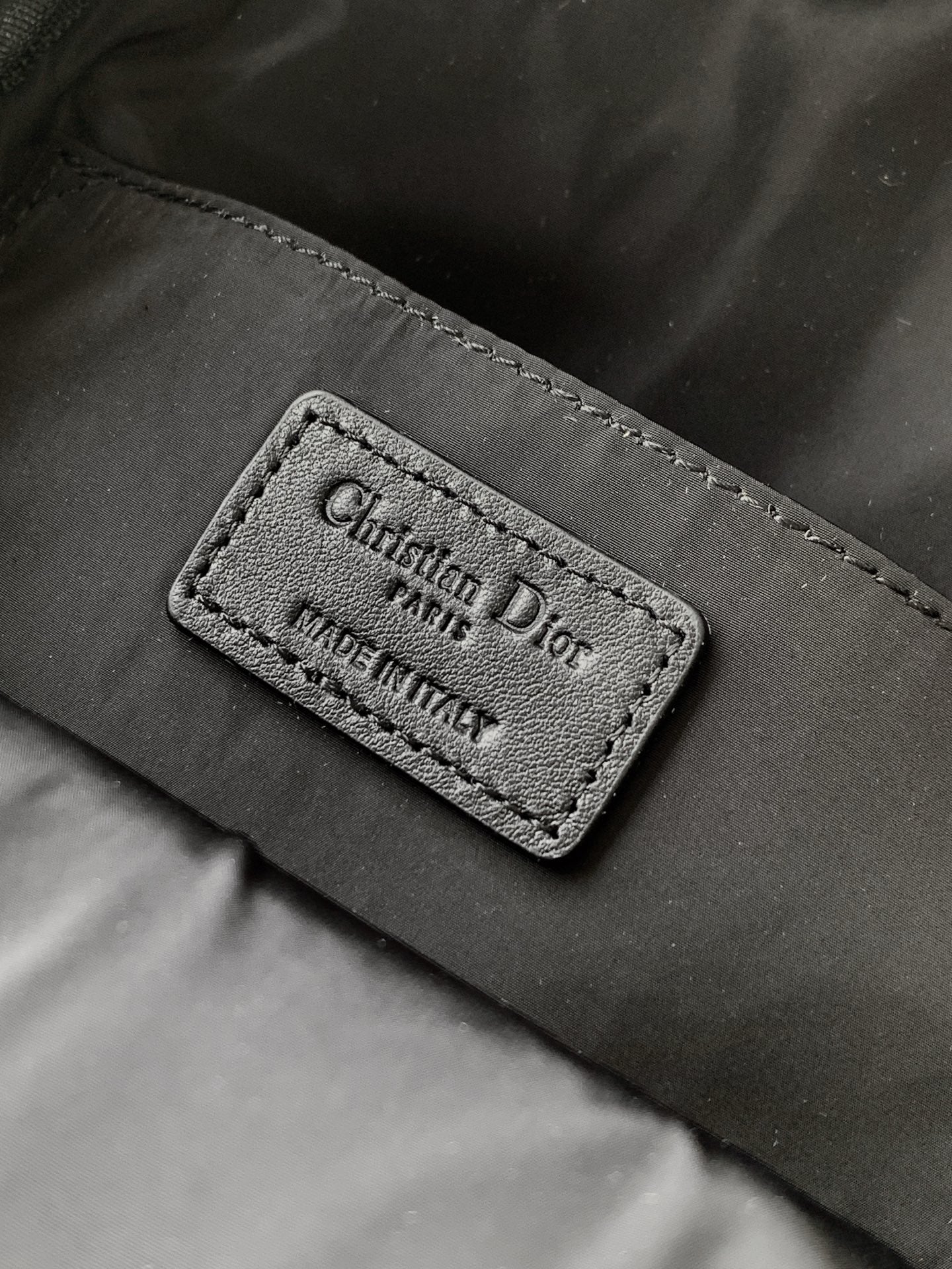 Dior bag internal label reading Christian Dior, Made in Italy on black fabric