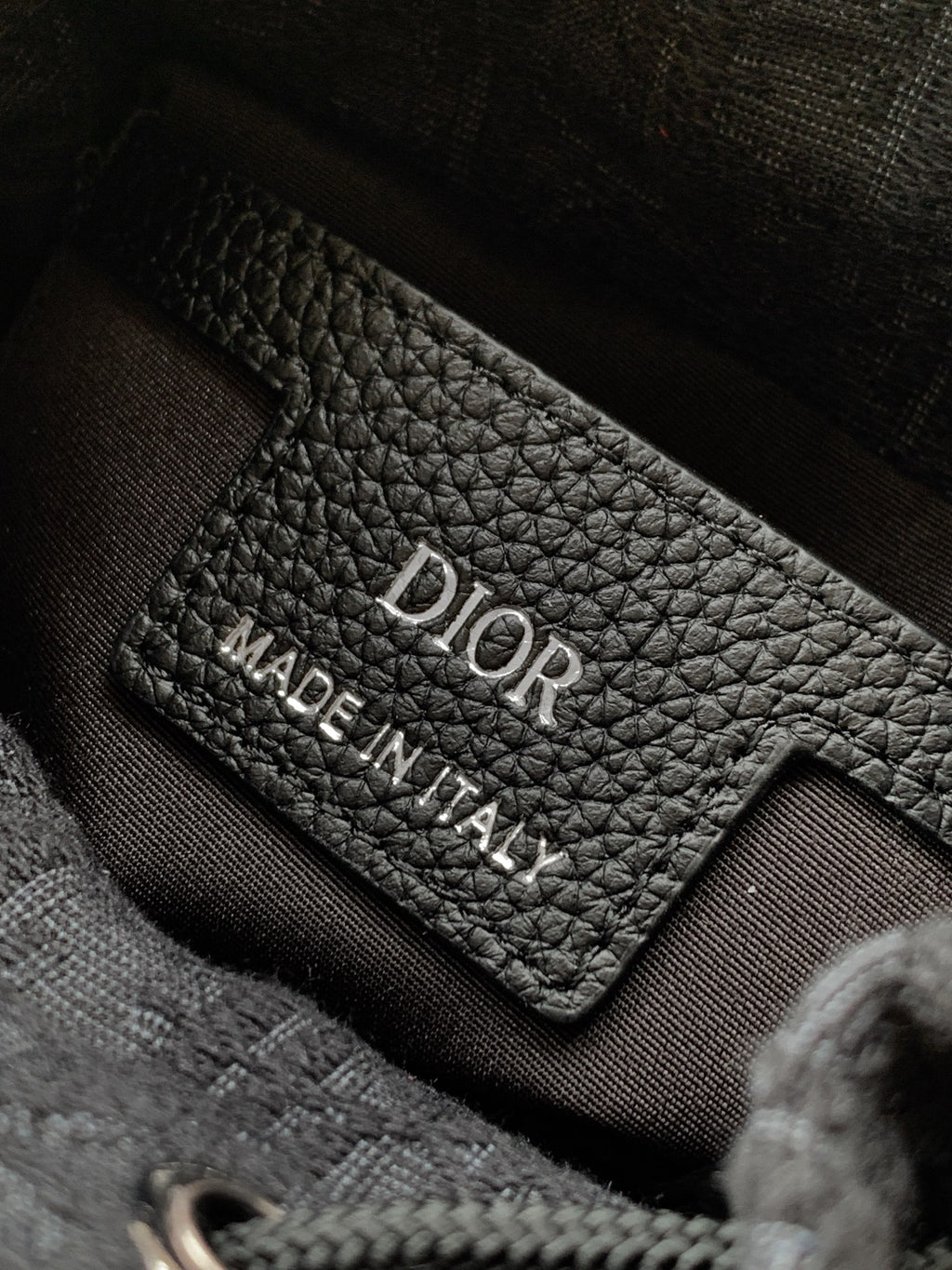 Interior Dior leather label on dark lining, 'Dior' and 'Made in Italy' text