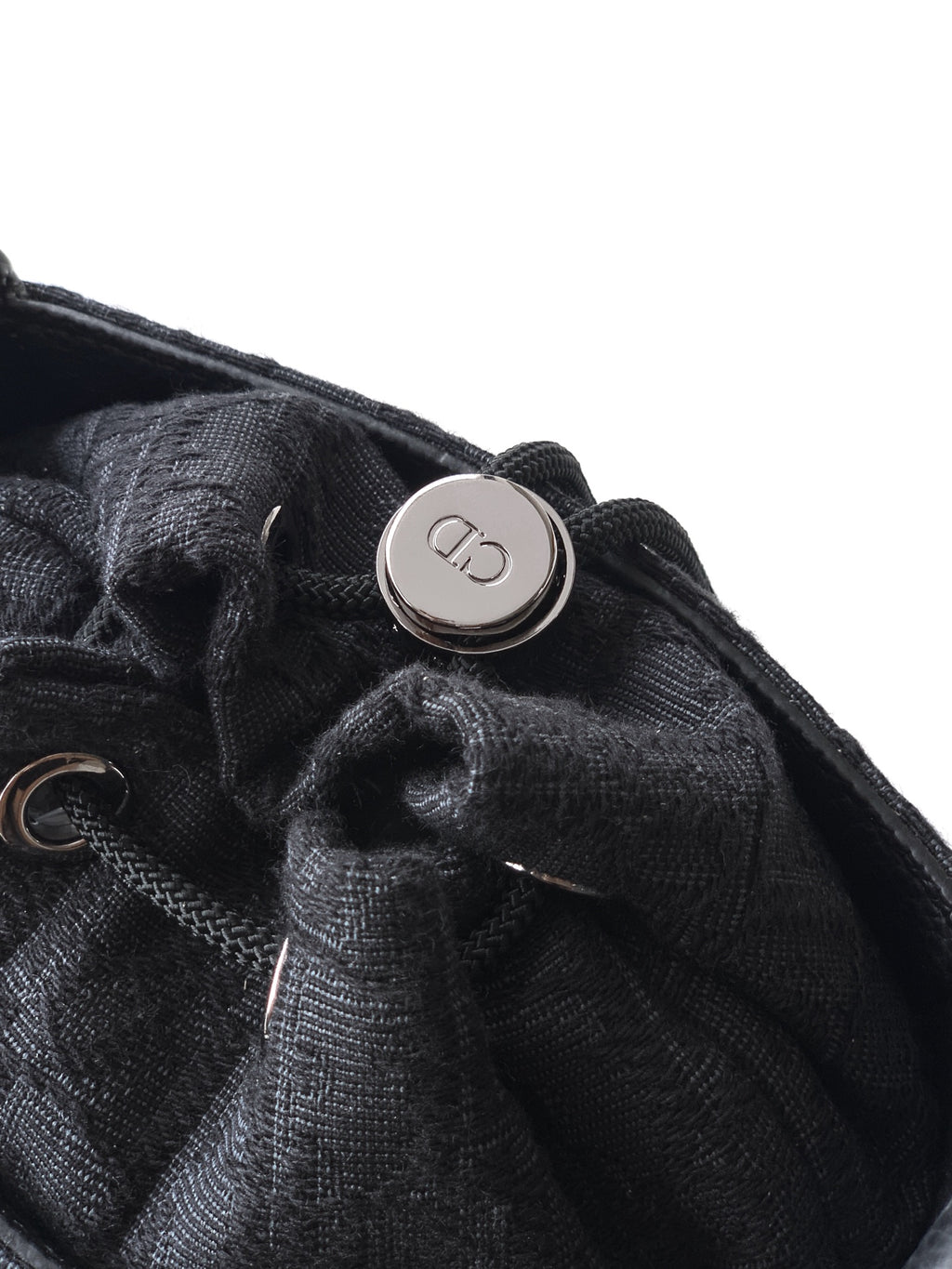 Dior logo snap detail on dark woven pouch with drawcord closure