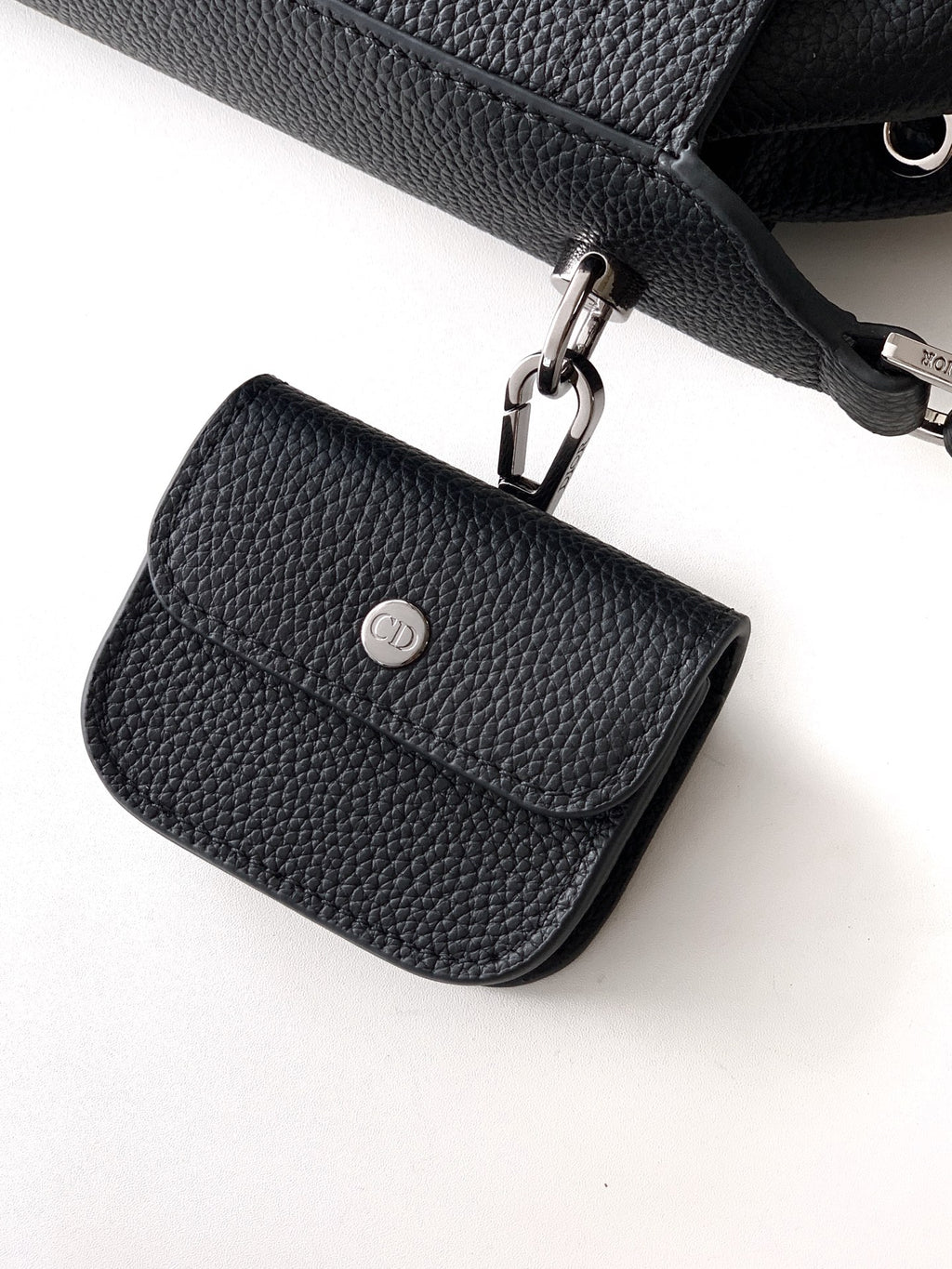 Small black leather flap bag with metal clasp and smooth front panel