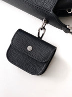 Small black leather flap bag with metal clasp and smooth front panel