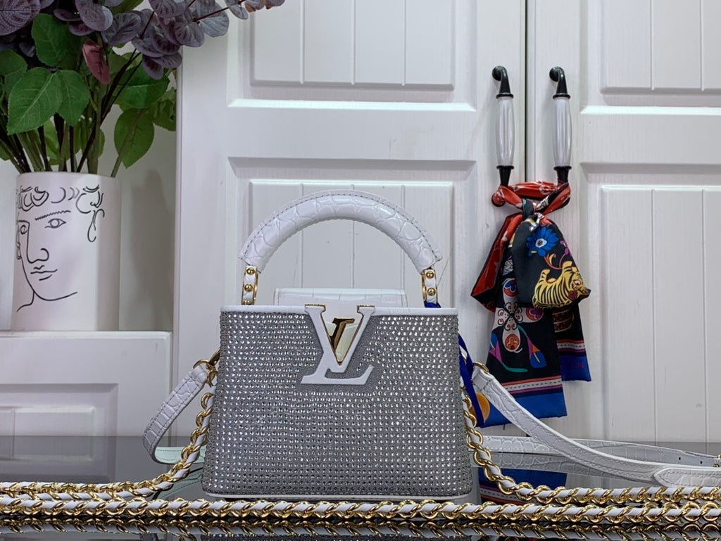 Louis Vuitton handbag in white, textured finish, gold LV logo, chain strap