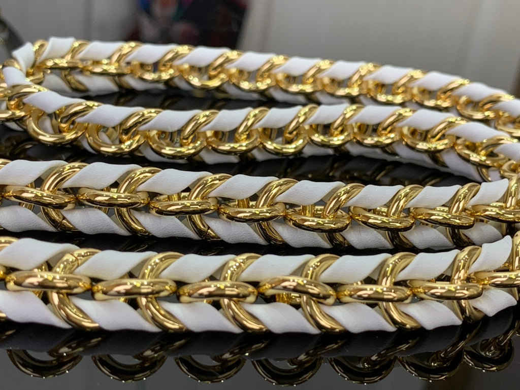 Gold and black chain on white handbag strap, interlocking links
