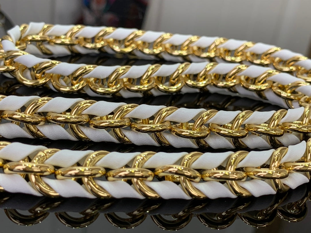 Gold and black chain on white handbag strap, interlocking links