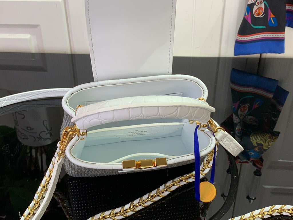 Open white handbag showing light lining and gold clasp at top