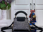 Black leather top handle mini bag with silver studded front and crossbody strap