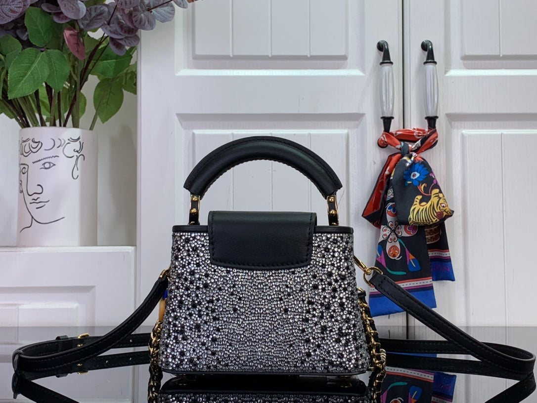 Black leather top handle mini bag with silver studded front and crossbody strap