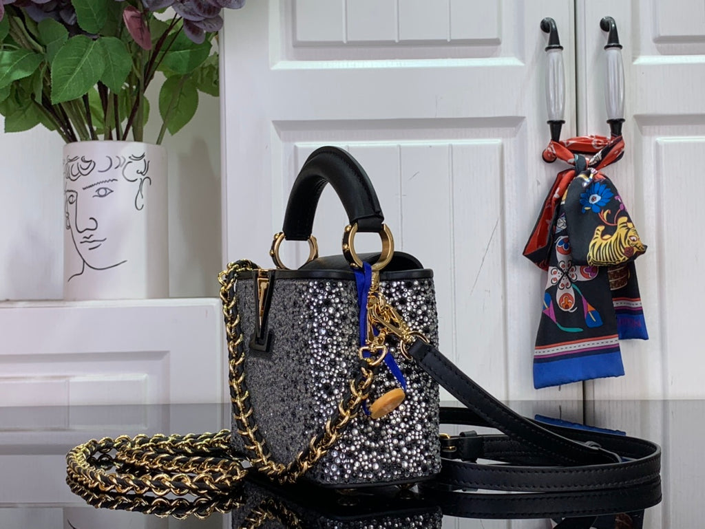 Black studded mini bag with gold chain detail and black shoulder strap