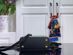 Black flap mini bag with gold corner studs and black crossbody strap