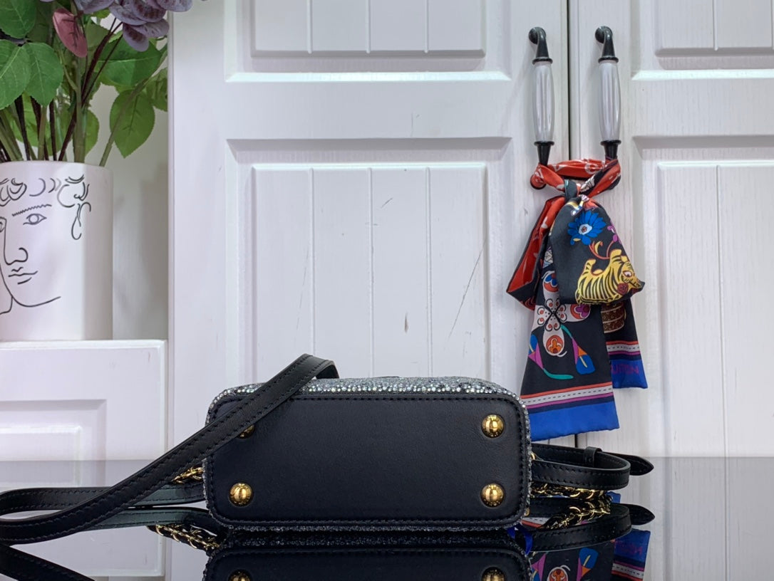 Black flap mini bag with gold corner studs and black crossbody strap