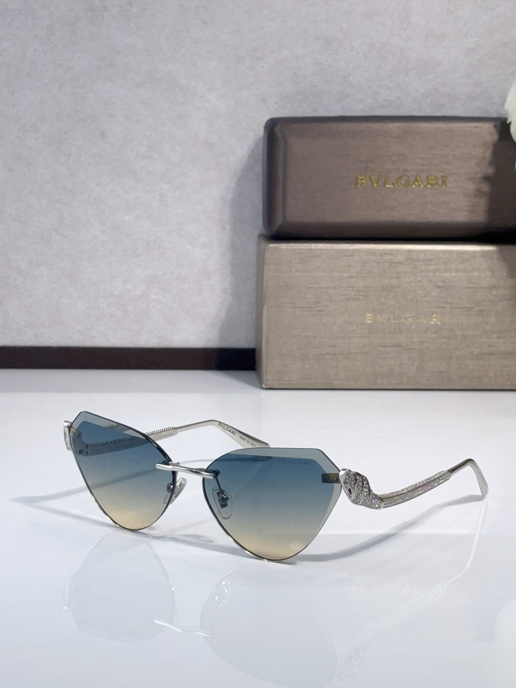 Bvlgari sunglasses with gold-tone frames and blue gradient lenses, cat-eye style