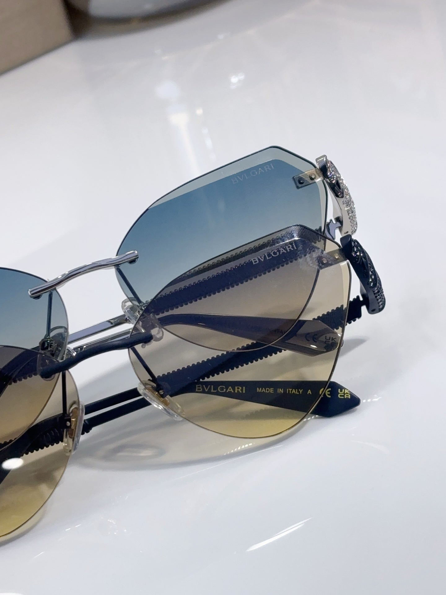 Bvlgari sunglasses close-up showing blue lenses, metal frame, and patterned temples