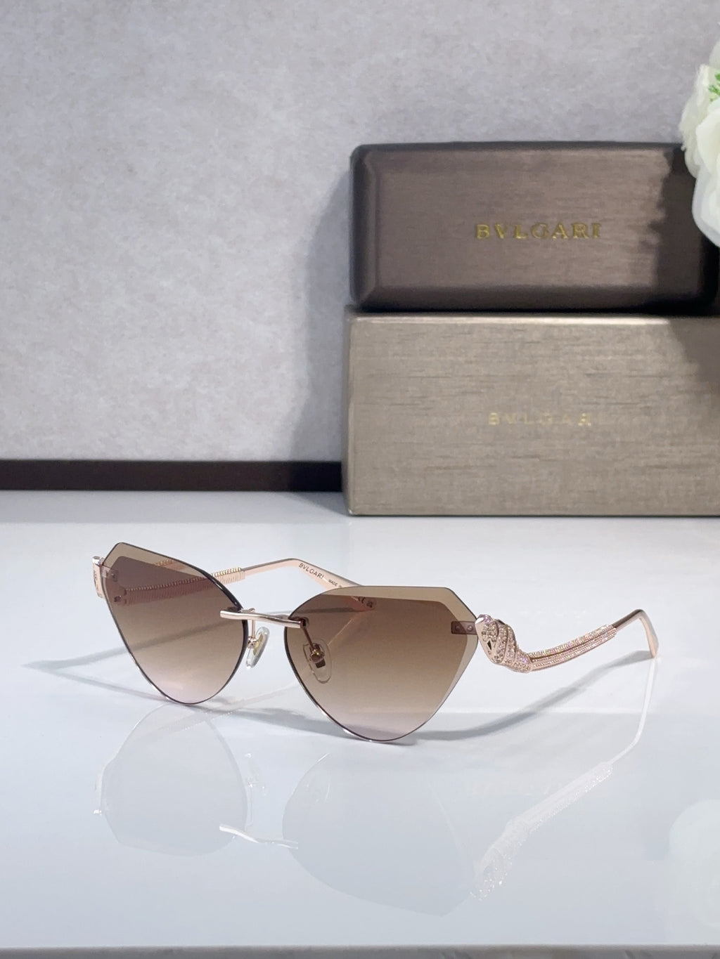 Bvlgari sunglasses with rose-gold frames and brown gradient lenses, cat-eye style