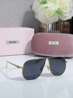 Gold-tone sunglasses with dark blue lenses, curved frame and pointed tips