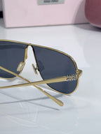 Side view of gold-tone sunglasses showing dark blue lens and metal temple details