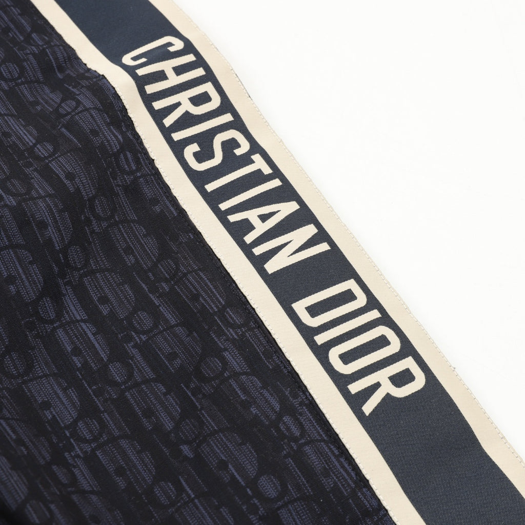 Christian Dior logo stripe on navy jogger pants with textured fabric