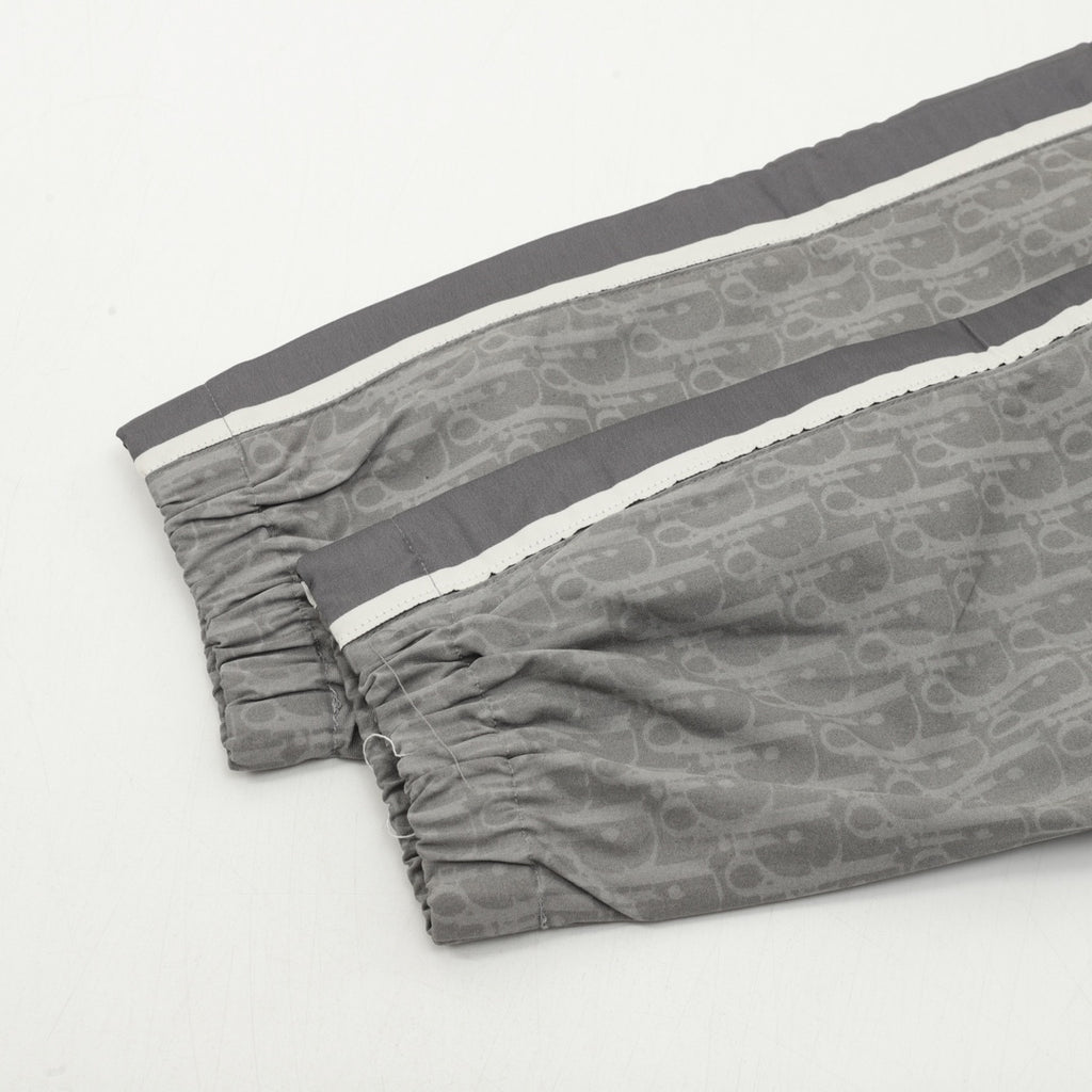 Dior pants with dark gray drape, elastic cuffs, and allover monogram pattern