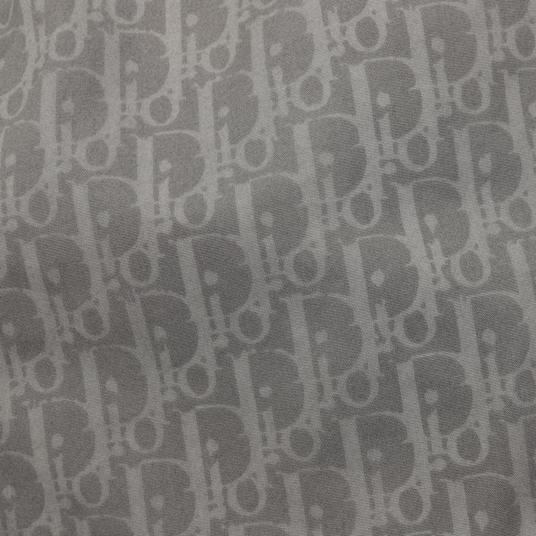 Close-up of grey Dior monogram fabric pattern on pants