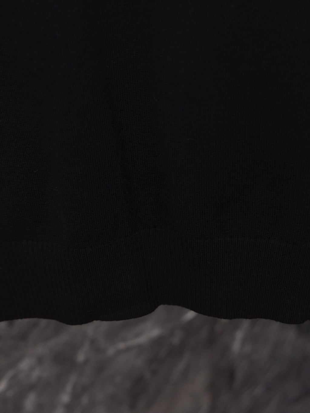 Black long-sleeve sweater hem close-up