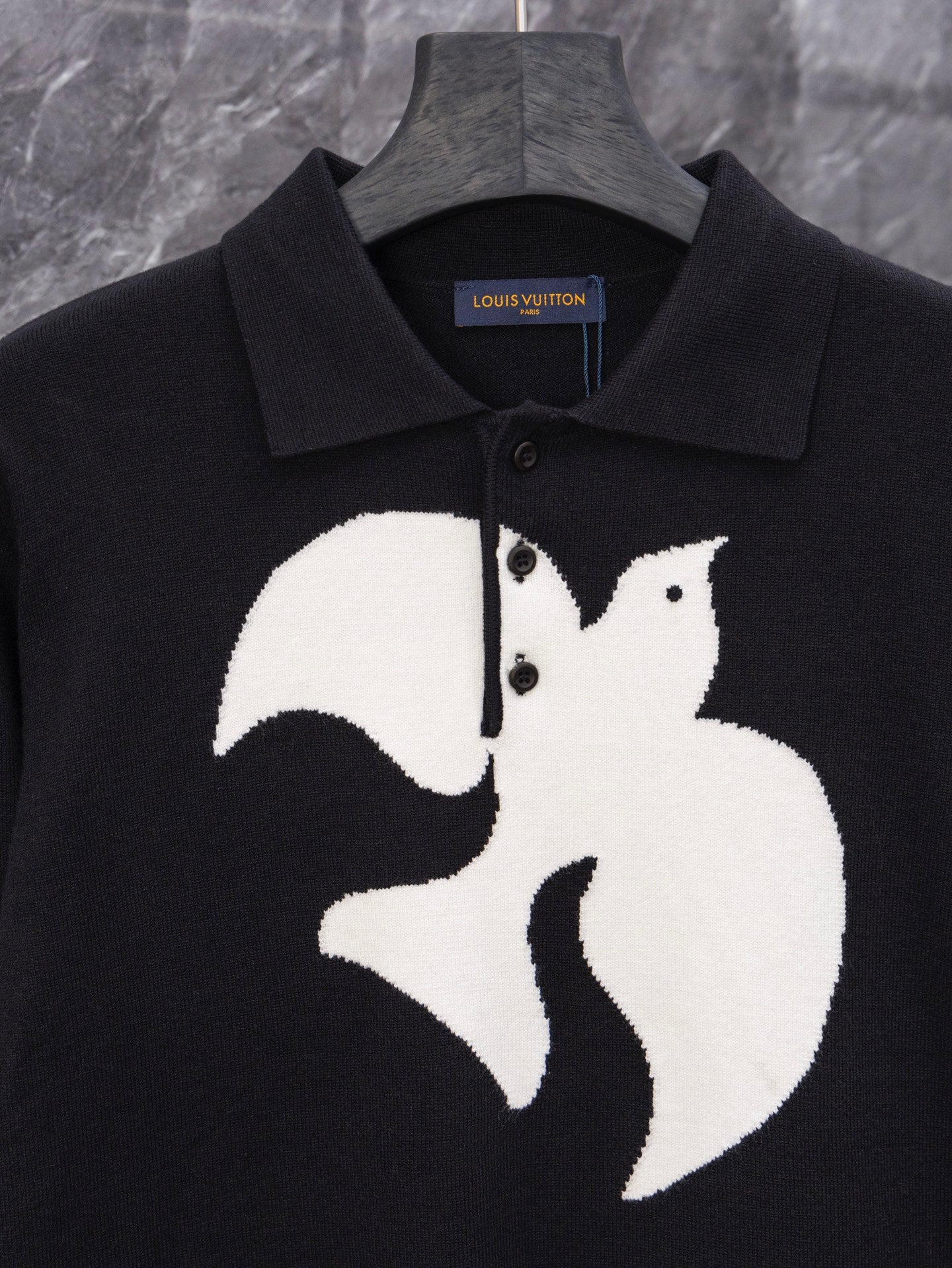 Black long-sleeve sweater with large white graphic emblem and ribbed collar
