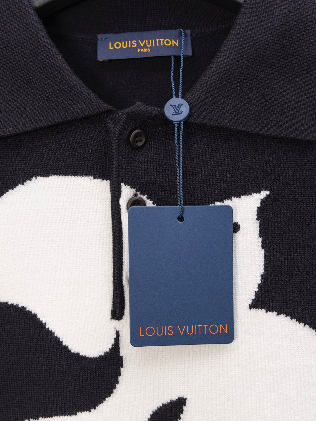 Black polo sweater close-up of button placket and Louis Vuitton neck label