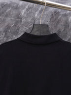 Black long-sleeve sweater top view on hanger, ribbed collar visible