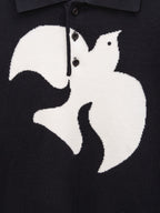 Black sweater chest graphic close-up with button placket detail