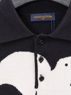 Black sweater placket close-up with buttons and white graphic print