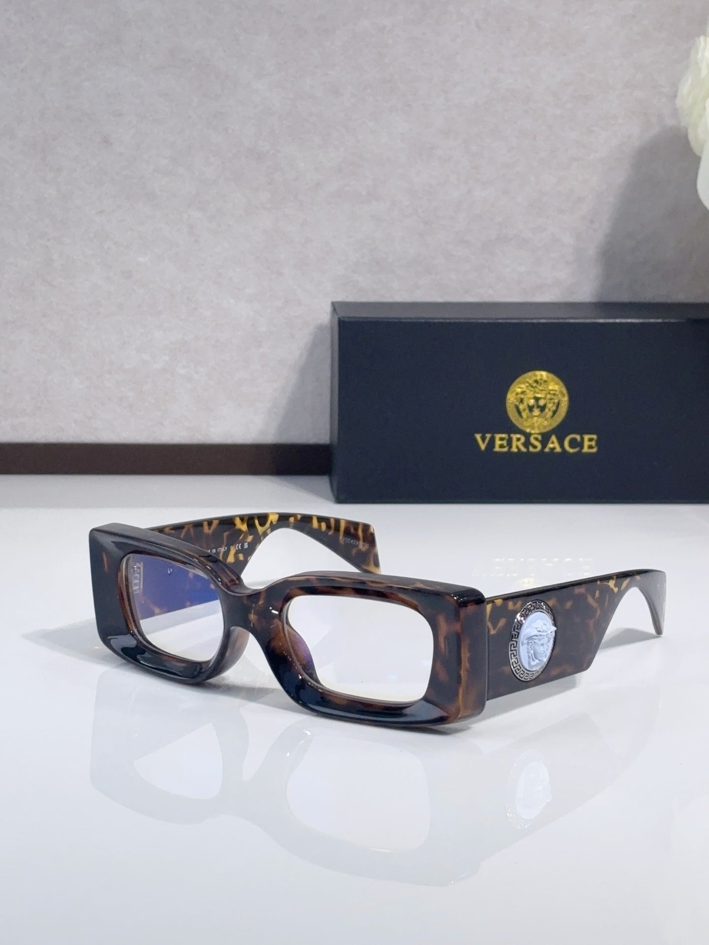 Versace cat-eye sunglasses, dark tortoiseshell frame with clear lenses and logo medallion