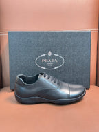 Prada leather lace-up sneakers in dark blue, low profile with stitched toe cap