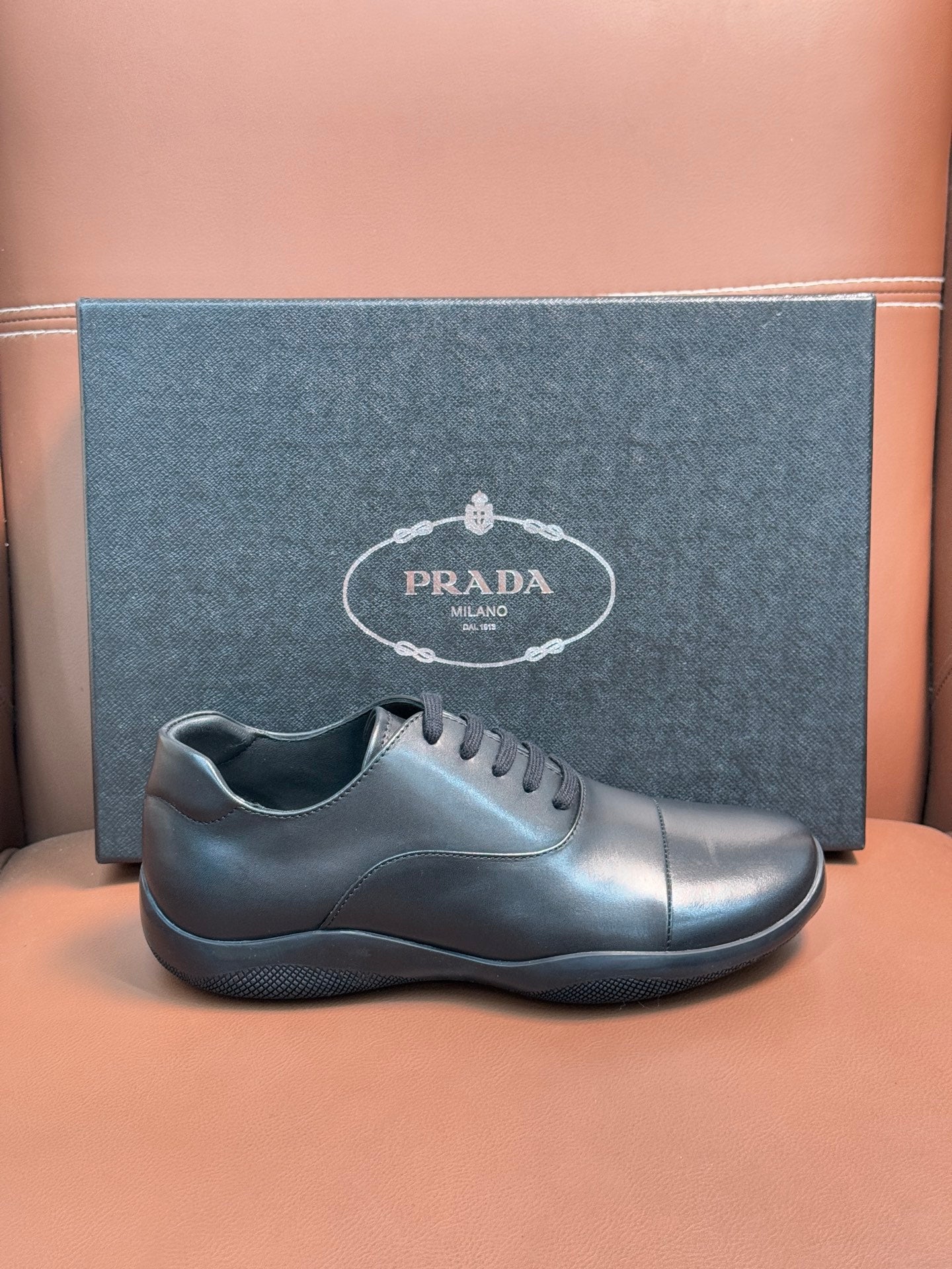 Prada leather lace-up sneakers in dark blue, low profile with stitched toe cap